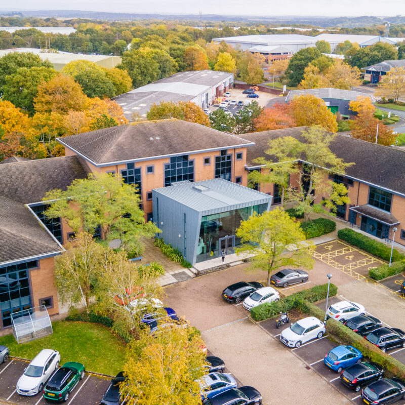 An overview of an office building with a bespoke reception and exterior car park.